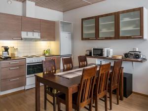 eine Küche mit Tisch und Stühlen in einem Zimmer in der Unterkunft Holiday Home Tuija by Interhome in Lahdenperä