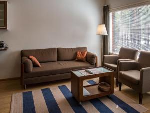ein Wohnzimmer mit Sofa und Tisch in der Unterkunft Holiday Home Tuija by Interhome in Lahdenperä + 14 Fotos