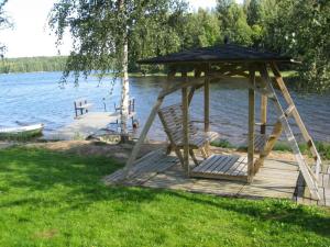 drewniana altana z ławką na przystani nad jeziorem w obiekcie Holiday Home Koivuranta by Interhome w mieście Sipsiö