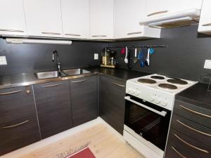 eine Küche mit weißem Herd und Spüle in der Unterkunft Holiday Home Pinea by Interhome in Niittymaa