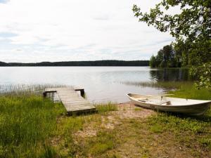 a boat on the shore of a lake with a dock at Holiday Home Keltalilja by Interhome in Sipsiö