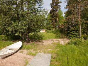 a boat sitting on the ground in a field at Holiday Home Keltalilja by Interhome in Sipsiö