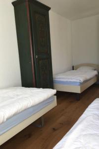 una camera con due letti e un armadietto verde di Apartment Turmalin 2- Stock by Interhome a Lenk