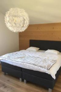 - une chambre avec un grand lit et un lustre dans l'établissement Apartment Turmalin 2- Stock by Interhome, à Lenk im Simmental