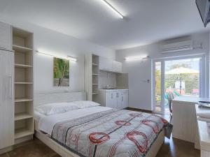 biała sypialnia z łóżkiem i kuchnią w obiekcie Apartment Nika-11 by Interhome w mieście Umag