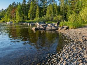 une rivière avec des rochers et des arbres sur la rive dans l'établissement Holiday Home Köllölä 1 by Interhome, à Nunnanlahti
