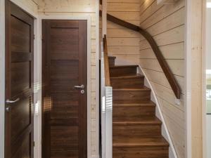 schody prowadzące do drewnianego domu z drewnianymi drzwiami w obiekcie Holiday Home Äkäsmartti a by Interhome w mieście Äkäslompolo