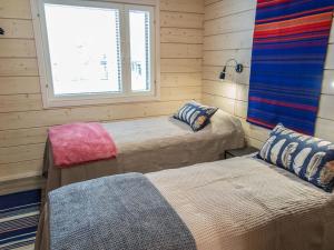 ein Schlafzimmer mit zwei Betten und einem Fenster in der Unterkunft Holiday Home Äkäsmartti a by Interhome in Äkäslompolo + 25 Fotos