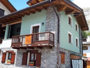 a house with a balcony on the side of it at Appartamento Collomb Ruitor in La Thuile