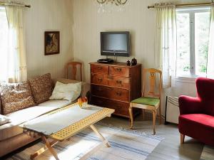 a living room with a couch and a tv on a dresser at Holiday Home Archipelago red cottage by Interhome in Dragsfjärd