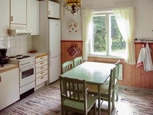 a kitchen with a table and chairs and a window at Holiday Home Archipelago red cottage by Interhome in Dragsfjärd