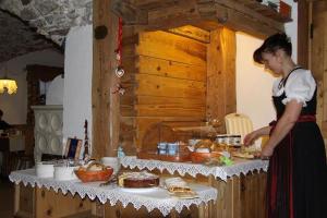 uma mulher em pé em frente a uma mesa com comida em Hotel Fonte Dei Veli em Panchia