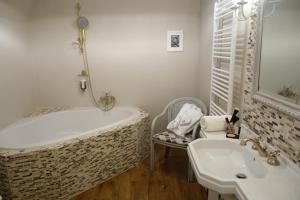 y baño con bañera y lavamanos. en Villa Bucher - Metnitztalerhof, en Friesach
