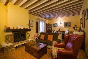 sala de estar con sofá y chimenea en Hotel La Casa del Canónigo en Caracenilla