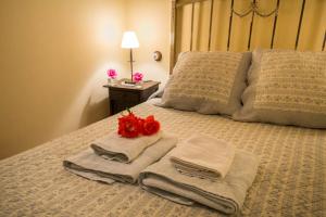 Una cama con toallas y una rosa roja. en Hotel La Casa del Canónigo, en Caracenilla