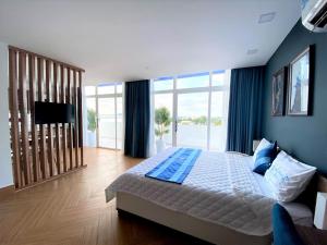 a bedroom with a large bed and a large window at Hung Phuoc Hotel in Bến Cát