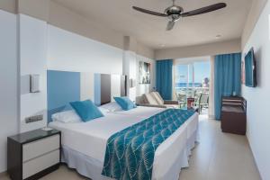 a hotel room with a large bed and a couch at Hotel Riu Costa del Sol - All Inclusive in Torremolinos