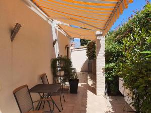a patio with a table and chairs under an orange umbrella at Apartmani Val in Pula