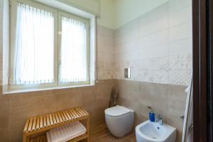 bagno con servizi igienici, lavandino e finestra di Villa Viuli a Torre del Greco