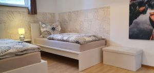 a bedroom with two beds and a picture on the wall at Moderne Ferienwohnung mit eigenem Garten und traumhaften Blick in Wilhelmsthal