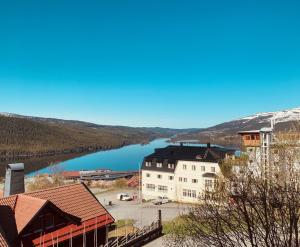 a large white building with a lake in the background at Åre Travel - Tottvillan in Åre