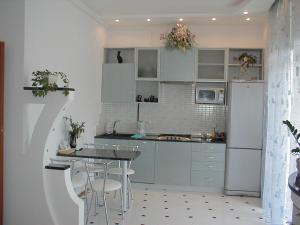 a kitchen with blue cabinets and a table and chairs at Ok Apartments near Palace Sporta - Kiev in Kyiv