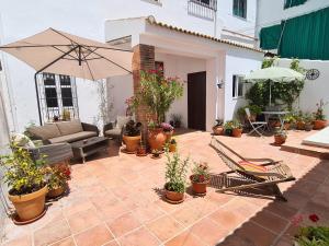 patio z kanapą, parasolem i roślinami w obiekcie Casa Alta Holiday Home w mieście El Esparragal
