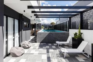 a patio with a pool and two chairs on a building at Quest Robina in Gold Coast