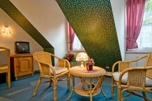 ハルバーシュタットにあるHotel Am Grudenbergのテーブル、椅子、テレビが備わる客室です。