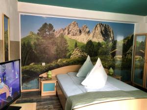 a bedroom with a mountain mural on the wall at Pensiunea Carina in Bran