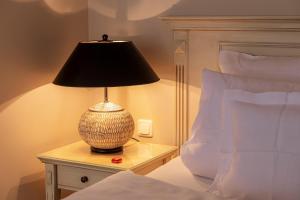 a lamp sitting on a table next to a bed at Strandhotel Fontana in Timmendorfer Strand