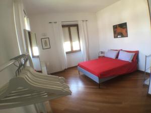 una camera con un letto rosso e una sedia di Casa Vacanze Magnolia a Borgo Ticino