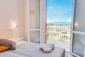 a bedroom with a bed and a view of the ocean at Mare Home Brunch&Beauty - Adults Only in Cesenatico