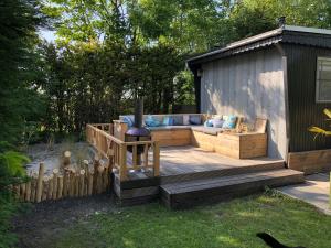 une terrasse en bois avec un canapé en face d'un hangar dans l'établissement Zeeuwse Landhoeve, à Brouwershaven