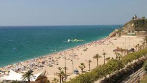 a beach with a lot of people and the ocean at Calella Skyline in Calella