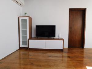 a living room with a television on a white wall at Free Terrace in Piran