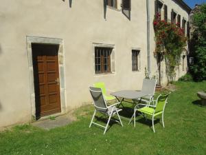 uma mesa e cadeiras em frente a um edifício em Chez Bernard et Michèle em Manglieu