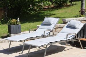 - un ensemble de quatre chaises longues assises sur une terrasse dans l'établissement Apartment am Nationalpark Bayerwald, à Lindberg