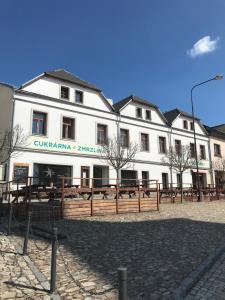 a large white building with a fence in front of it at Apartmány v pivovaru in Kašperské Hory