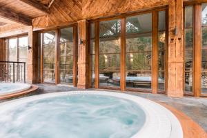 a hot tub in a house with windows at Aries Hotel & SPA Wisła in Wisła