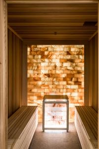 a room with two benches in front of a stone wall at Aries Hotel & SPA Wisła in Wisła