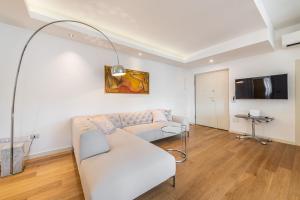 a living room with a white couch and a tv at A Luxury apartment at Cagliari Poetto Beachfront in Cagliari