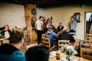 a group of people sitting in a room with a band at Vinný sklep u Műhlbergerů in Jaroslavice