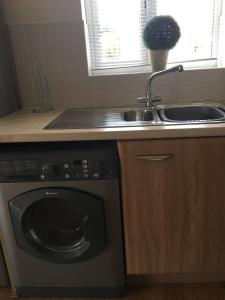 a kitchen with a sink and a dishwasher at Penthouse Apartment On The River - 65 Skipper Way in Saint Neots