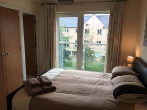 uma cama num quarto com uma grande janela em Penthouse Apartment On The River - 65 Skipper Way em Saint Neots