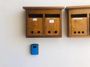 dois armários de madeira e uma caixa azul numa parede em Casa bianca em San Vito di Cadore