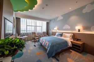 um quarto com uma cama, uma mesa e cadeiras em Qilian Pearl Hotel Zhangye em Zhangye