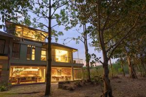 a house in the middle of some trees at Kaav Safari Lodge, Kabini in Begūr