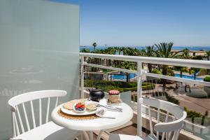 una mesa con un plato de comida en el balcón en Gran Palas Hotel - Spa incluido en La Pineda