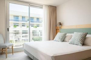 een slaapkamer met een bed en een groot raam bij Gran Palas Hotel - Spa incluido in La Pineda